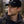 Man wearing a black cap with 'Moonvalley' logo in a forest setting