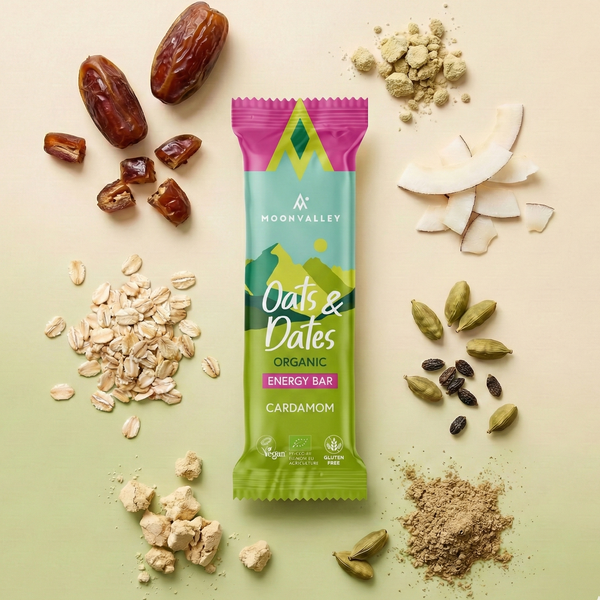 Organic Cardamom energy bar surrounded by dates, oats, cardamom seeds, and coconut.