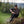 A man sitting on a rock in a forest eating a Moonvalley energy bar.