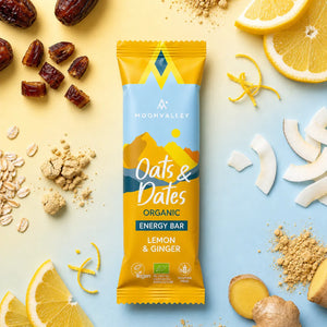 Organic Lemon & Ginger energy bar surrounded by fresh lemon slices, ginger root, oats, and dates.