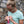 A woman in a blue t-shirt opening a Moonvalley Orange & Red Beet energy bar.