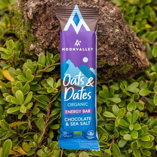 Moonvalley organic Chocolate & Sea Salt energy bar, photographed in a natural outdoor setting.