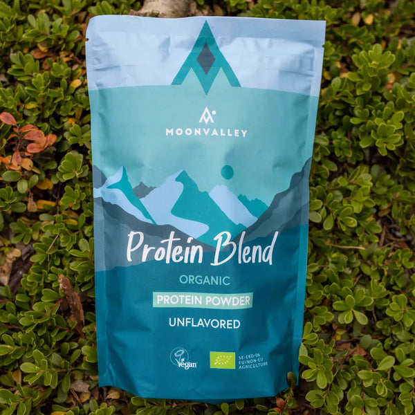 Moonvalley organic unflavoured protein powder in a resealable pouch, photographed in a natural outdoor setting.