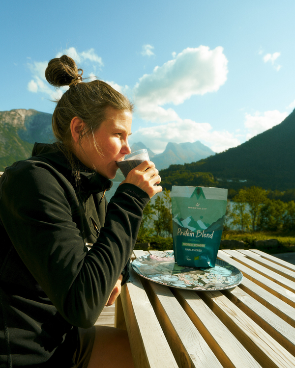 Person enjoying a healthy meal outdoors with a bag of Moonvalley protein powder.