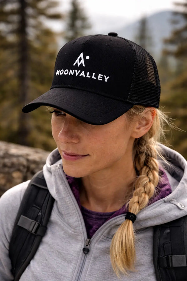 Person wearing a Moonvalley cap during an outdoor hiking adventure.