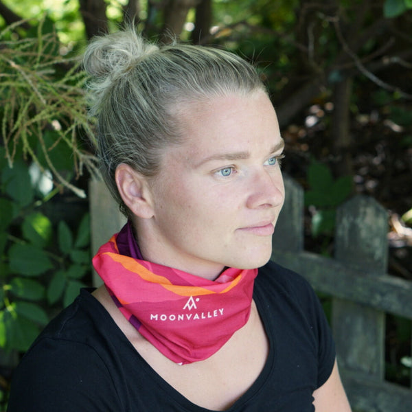 Woman wearing a red Moonvalley Mountain Tube around her neck.